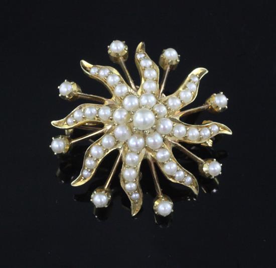 An Edwardian gold and graduated split pearl swirl sunburst pendant brooch, 31mm.
